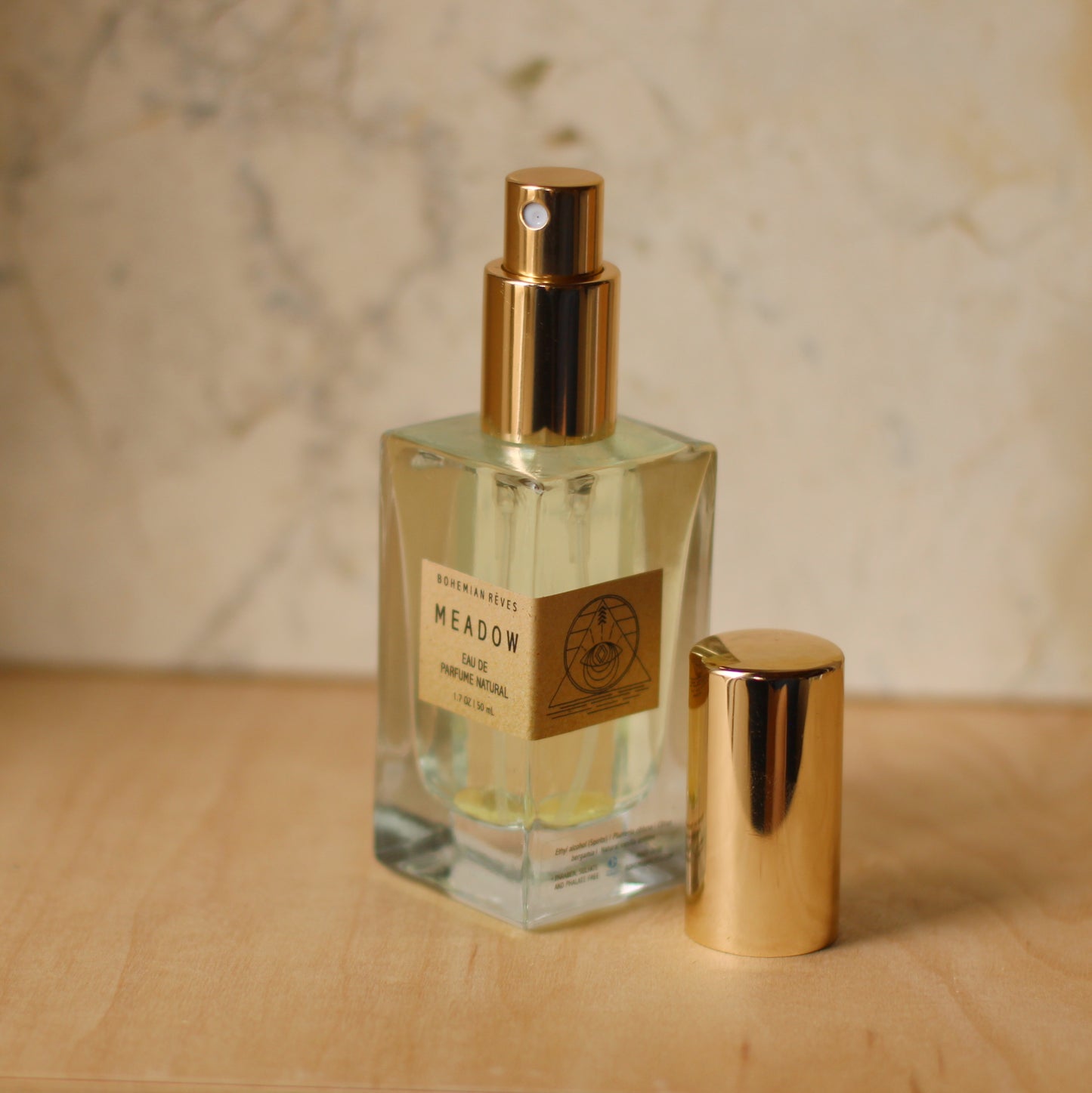 glass bottle of perfume with uncapped gold sprayer 